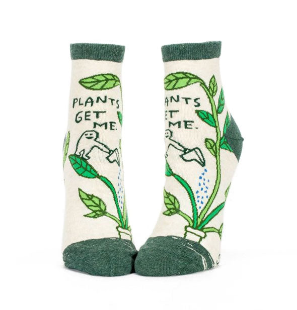 Socks with illustration of cartoon character watering a large houseplant say, "Plants get me."