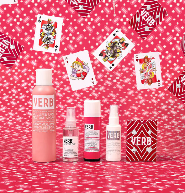 Bottles of Verb Volume Dry Texture Spray, Ghost Oil, Dry Shampoo, and Glossy Shine Spray with card deck pack against a red and white patterned backdrop scattered with playing cards
