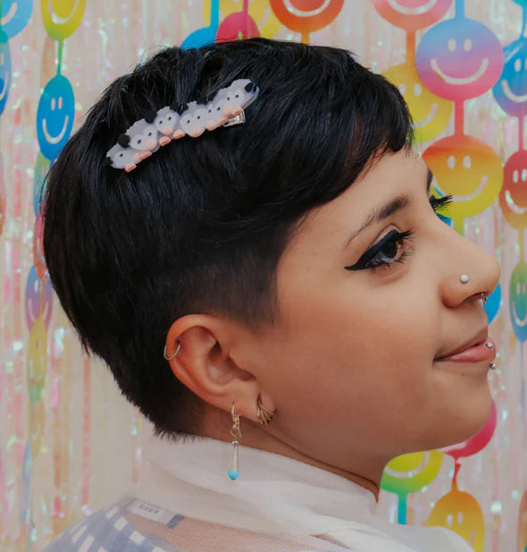 Model with short hair wears a hair clip with lineup of six possum babies