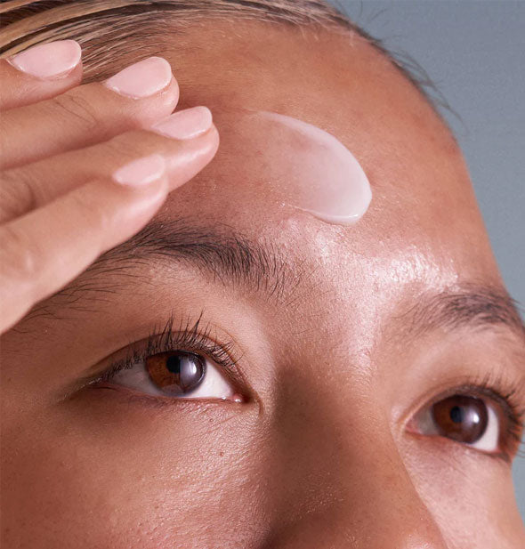Model applies Dermalogica Pro-Collagen Banking Serum to forehead