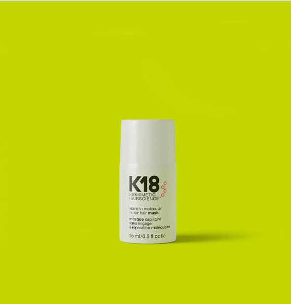 White  half-ounce bottle of K18 Biomimetic Hairscience Leave-in Molecular Repair Hair Mask on a bright lime green background