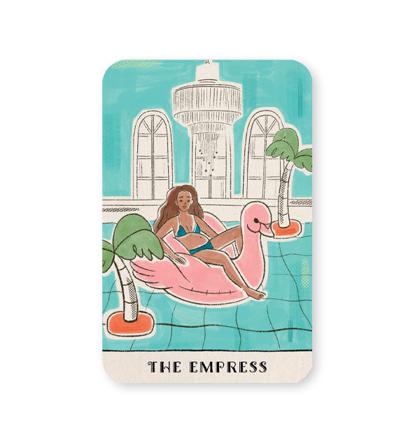 The Empress card from the Real Talk Tarot deck features a woman reclined on a pink flamingo floatie in an extravagant indoor pool