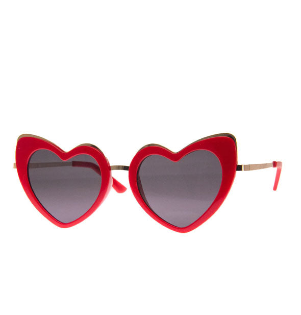 Pair of red heart-shaped sunglasses with gold details and red temple tips