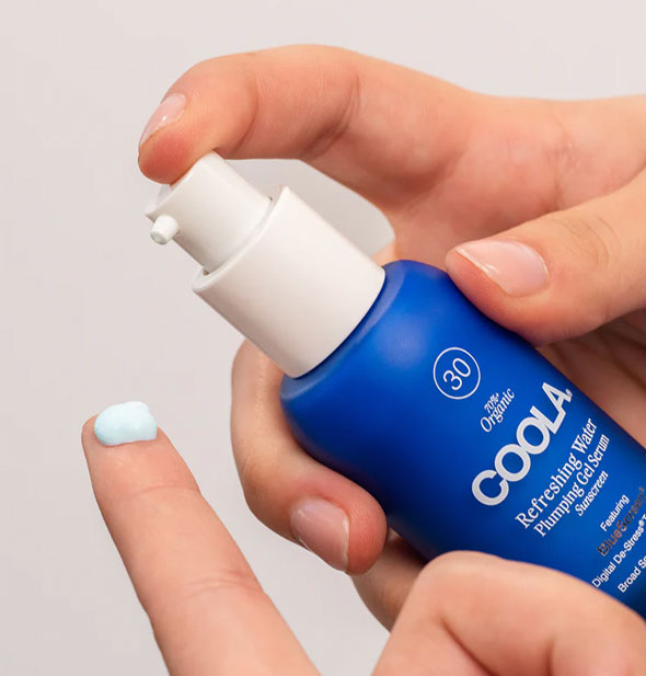 Model applies a small dollop of Coola Refreshing Water Plumping Gel Serum to fingertip