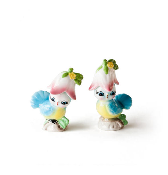 Set of two ceramic bird salt and pepper shakers, each appearing to perch on a twig and wearing a flower hat