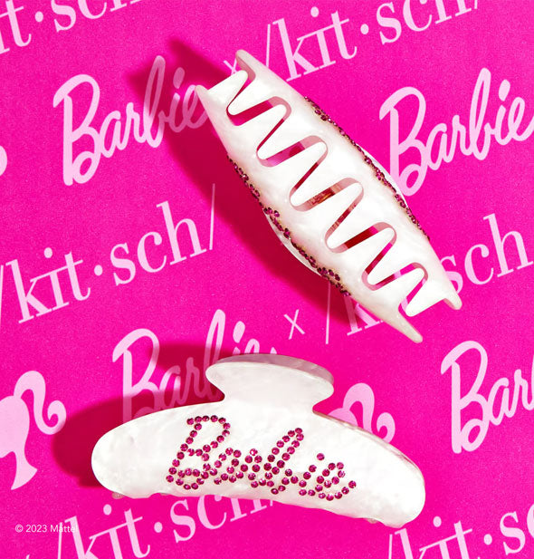 Two rhinestone Barbie claw clips on a pink Barbie x Kitsch logo backdrop, one resting on its side and the other on end to show teeth