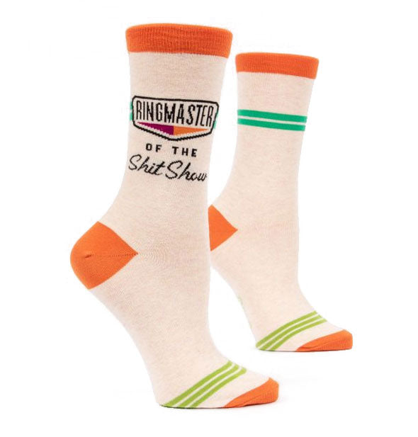 Pair of off-white socks with orange toes, heels, and top bands and green accent stripes say, "Ringmaster of the Shit Show" on the outside ankle