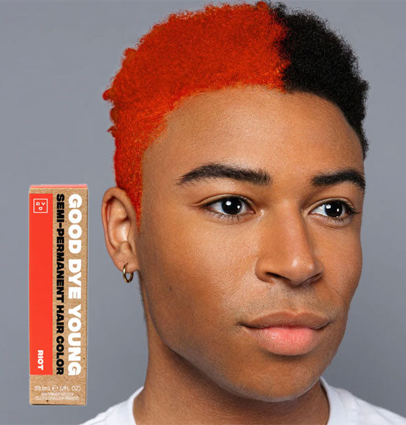 Model wears hair half dark and half bright orange; box of Good Dye Young Semi-Permanent Hair Color in shade Riot is inset at bottom left