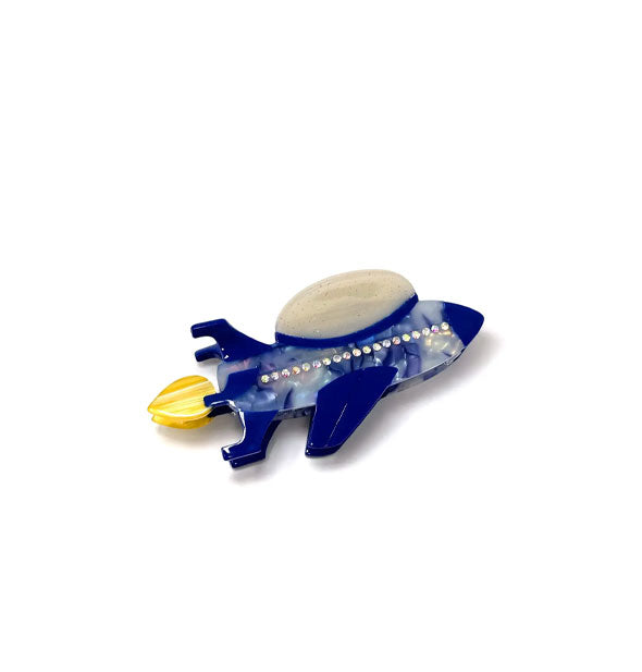 Mottled blue rocket ship hair clip with yellow flame and rhinestone accents