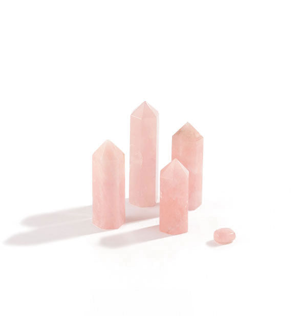 Collection of five rose quartz stones, four of which are tall with pointed tops