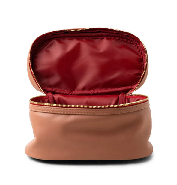 Terracotta vegan leather travel case with deep red zipper tape and gold-toned zipper is opened to show red nylon lining