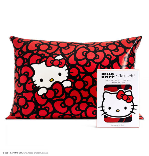 Package of one Hello Kitty x Kitsch Satin Pillowcase with standard size pillowcase shown behind featuring an all-over red bow pattern and Hello Kitty's white face and paws peeking out at left