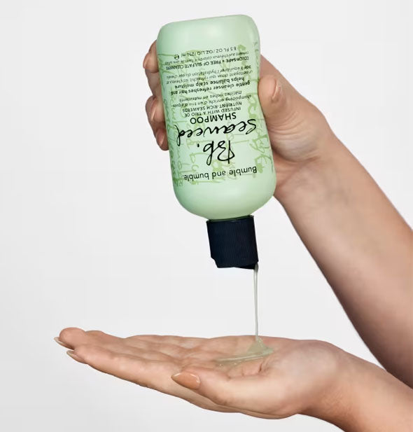 Model dispenses Bumble and bumble Seaweed Shampoo into palm