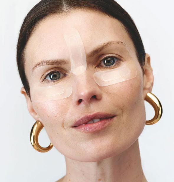 Model wears Wrinkles Schminkles Self-Dissolving Microneedle Patches under eyes and between eyebrows