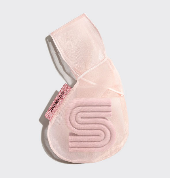 Pink mesh bag holds an S-shaped wash bar and features a pink sparkly tag that says, "Shampoo"