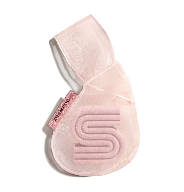 Pink mesh bag holds an S-shaped wash bar and features a pink sparkly tag that says, "Shampoo"