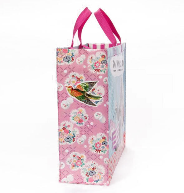 Side of a tote bag with pink handles featuring collage-style bird and flowers artwork
