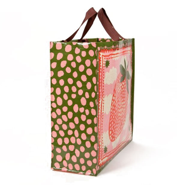 Square shopping bag with brown top handles features an all-over green and pink strawberry and clouds design with a rough polkadot side panel