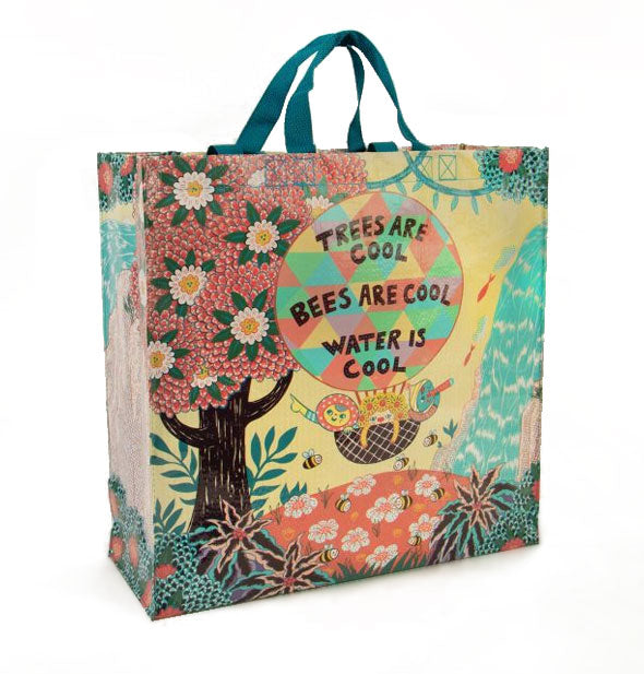 Square shopping bag with teal top handles features an all-over colorful design of animals floating in a hot air balloon over a natural scene with the words, "Trees are cool, bees are cool, water is cool"