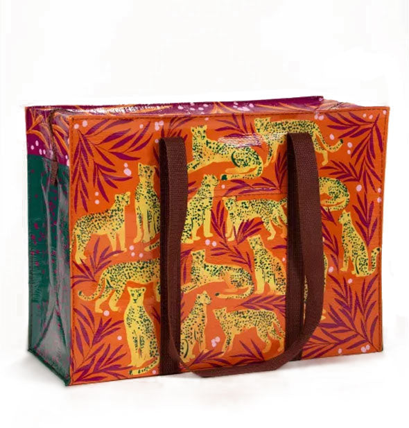 Rectangular orange shoulder bag with brown straps features all-over illustrations of yellow cheetahs among burgundy branches