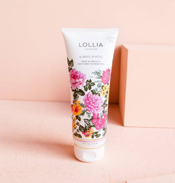 White tube of Lollia Always In Rose Perfumed Shower Gel features a colorful floral design on its lower two-thirds