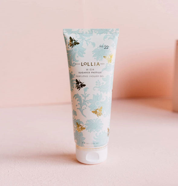 White bottle of Lollia Wish Sugared Pastille Perfumed Shower Gel with blue floral design accented by gold bees