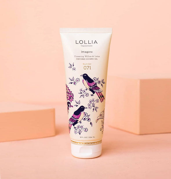 White 8 ounce tube of Lollia Imagine Flowering Willow & Lotus Perfumed Shower Gel features blue and purple birds and floral design accented by gold at the bottom