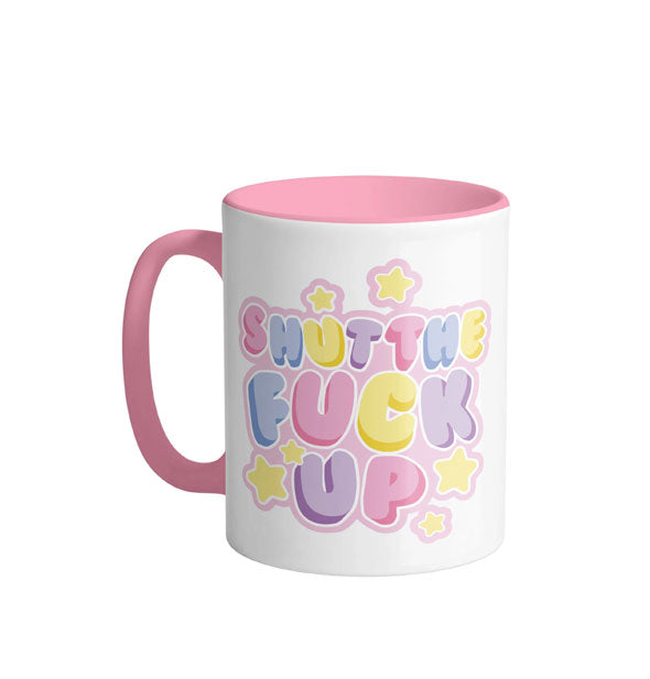 White coffee mug with pink handle and interior says, "Shut the fuck up" in multicolored pastel bubble lettering accented by yellow stars