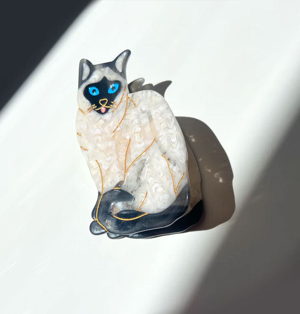 Hair clip designed and painted to resemble a Siamese cat with blue eyes