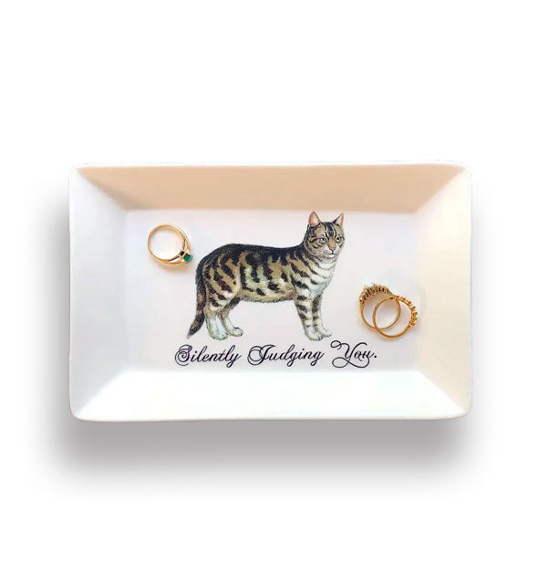 Rectangular white porcelain dish holding three gold rings features illustration of a tabby cat above the caption, "Silently Judging You" in black script