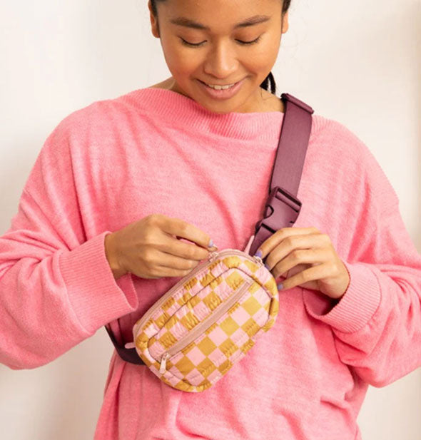 Model wears a pastel checkered belt bag in a crossbody fashion