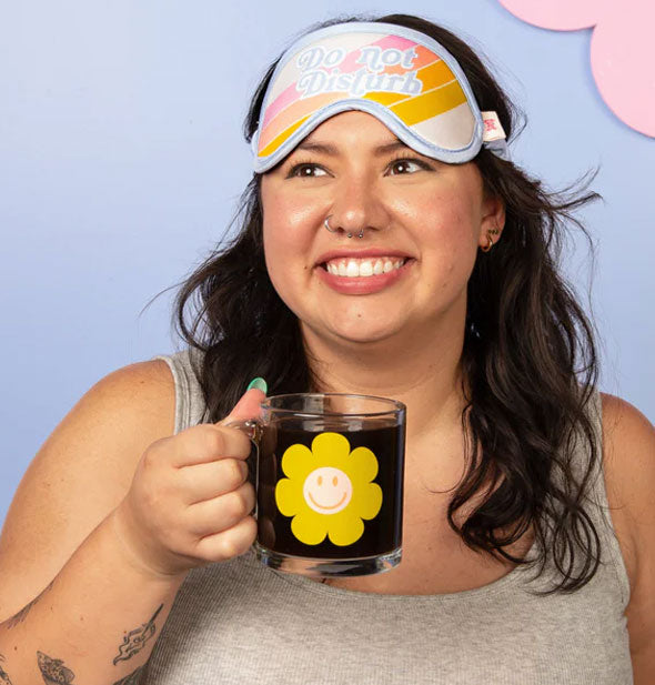 Smiling model holds a Smiley Flower Glass Mug filled with a dark beverage by the handle