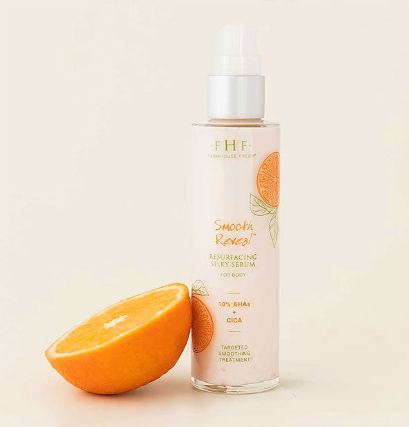Bottle of FarmHouse Fresh Smooth Reveal Resurfacing Silky Serum for Body is staged with half an orange