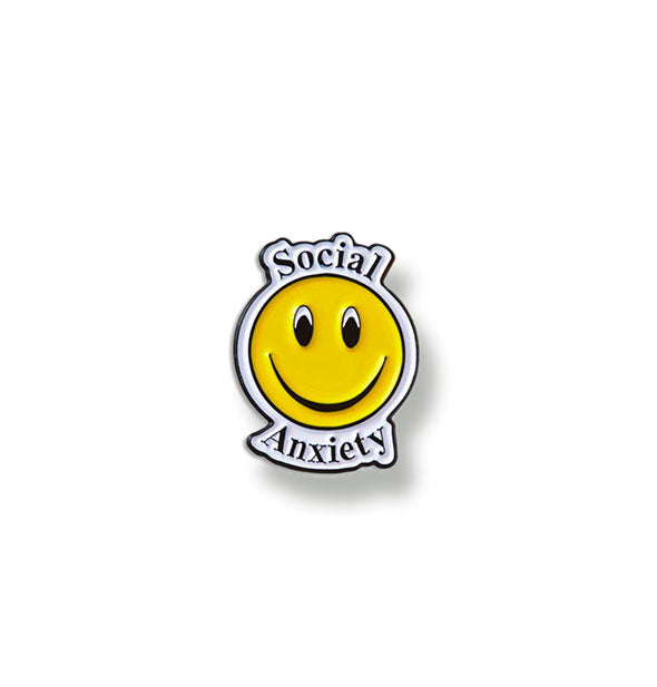 Enamel pin with central yellow smiley face says, "Social Anxiety" in black lettering