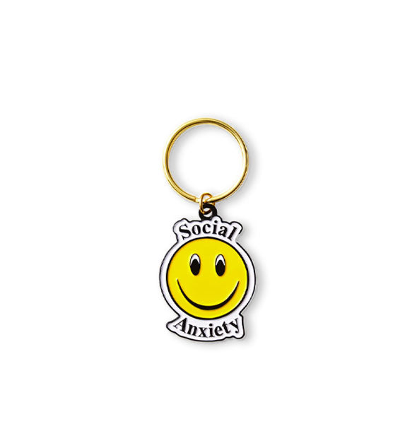 Enamel keychain on gold ring features a yellow smiley face and the words, "Social Anxiety" in black lettering