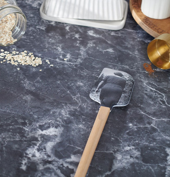 Vintage black and white photograph spatula rests on a marble countertop with some spilled ingredients in the background