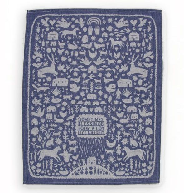 Blue dish towel with all-over illustrations of farm animals, hearts, flowers, and houses says, "Sometimes blessings look a lot like bullshit" in a central raincloud pouring down onto a house on a hill in which vegetables represent a garden