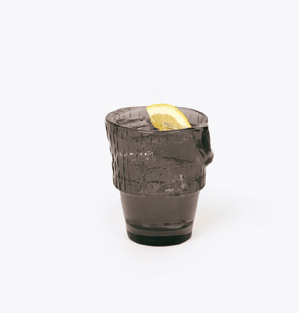 Black textured drinking glass with lime wedge garnish inside