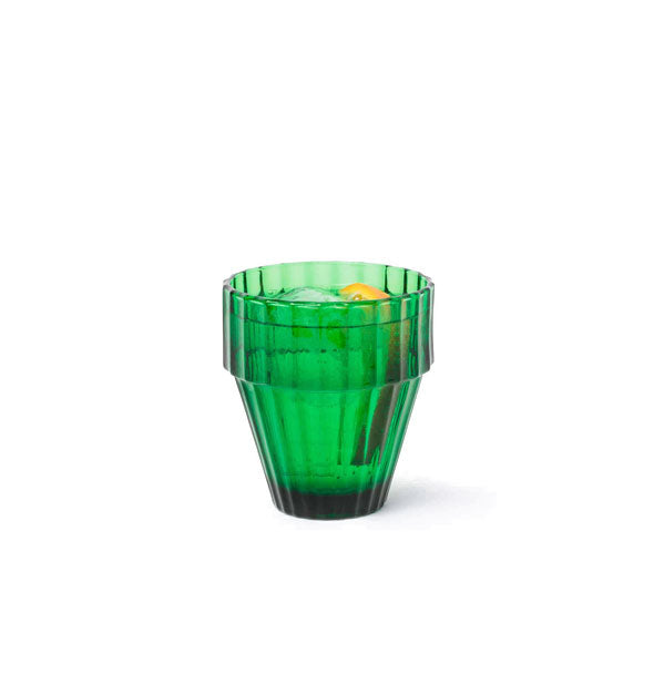 Ribbed green drinking glass filled with a garnished beverage