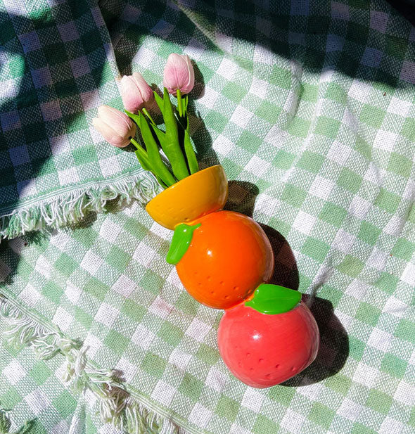 Stacked Citrus Vase staged with pink tulips on a green gingham cloth
