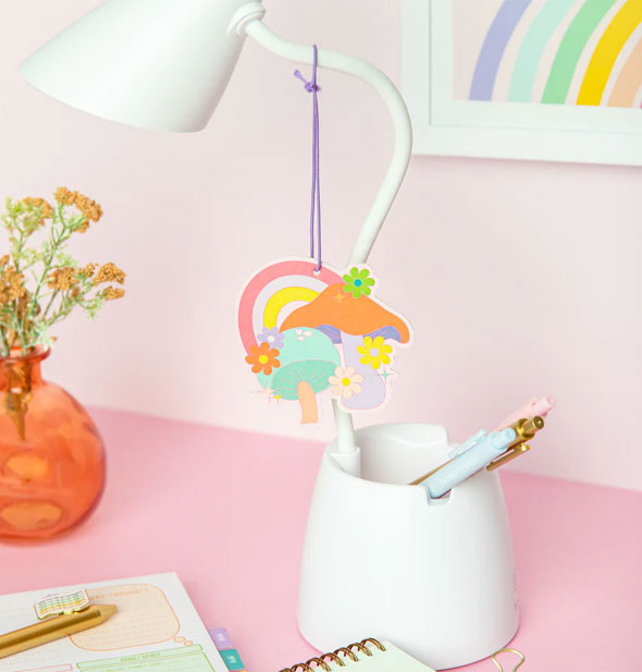 Stardust Mushroom air freshener shown hanging from the neck of a white desk lamp cup holder