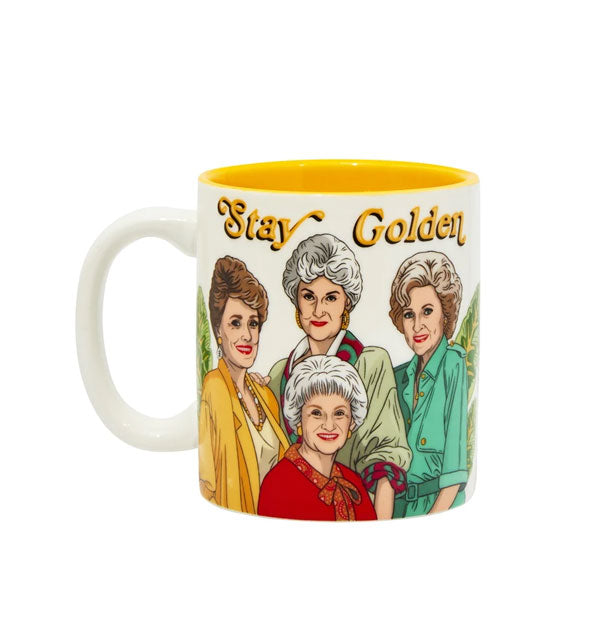 White coffee mug with yellow interior features colorful illustration of The Golden Girls main characters under the words, "Stay Golden" in yellow italic print