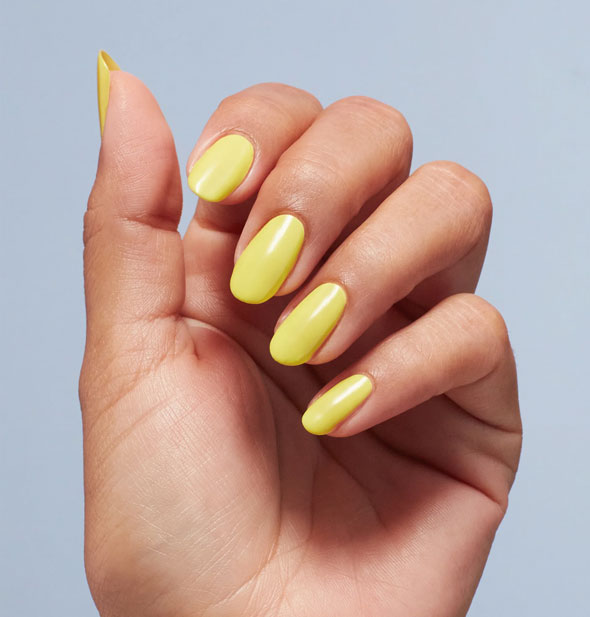 Model's fingernails are painted with yellow nail polish