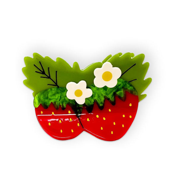 Hair clip designed to resemble two strawberries with green leaves and white flowers with yellow centers