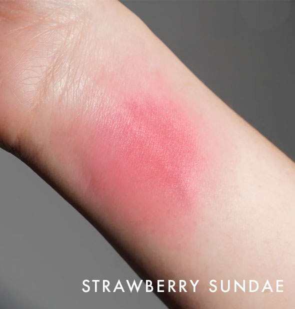 Kara Beauty Soft Serve Lip & Cheek Whip shade Strawberry Sundae is applied to the inside of a model's wrist