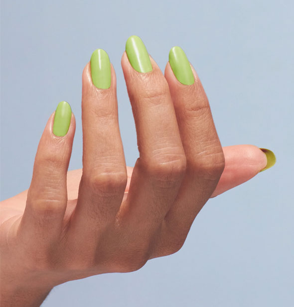 Model's fingernails are painted with lime green nail polish