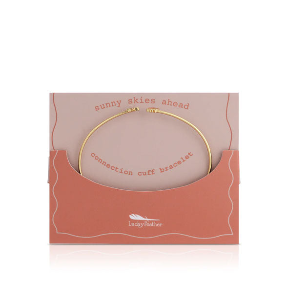 Thin gold Sunny Skies Ahead Connection Cuff Bracelet by Lucky Feather tucked into a two-tone pink envelope
