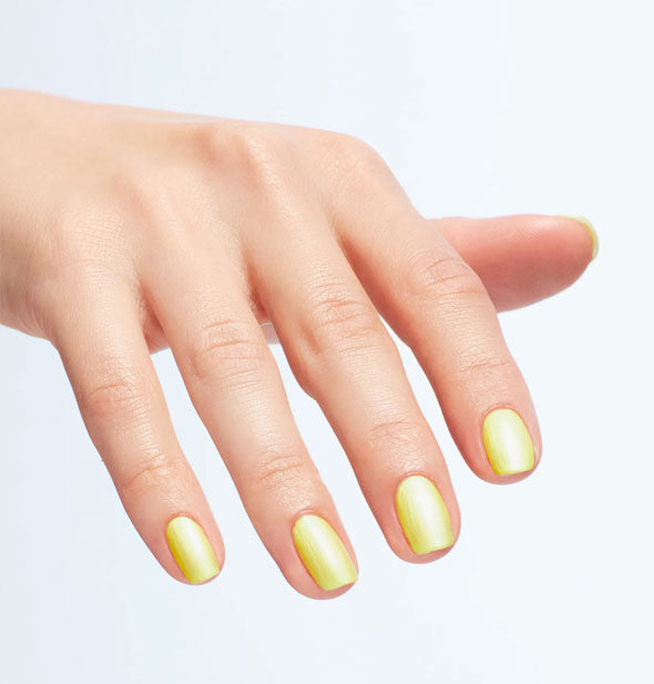 Model's fingernails are painted with pearlescent yellow polish