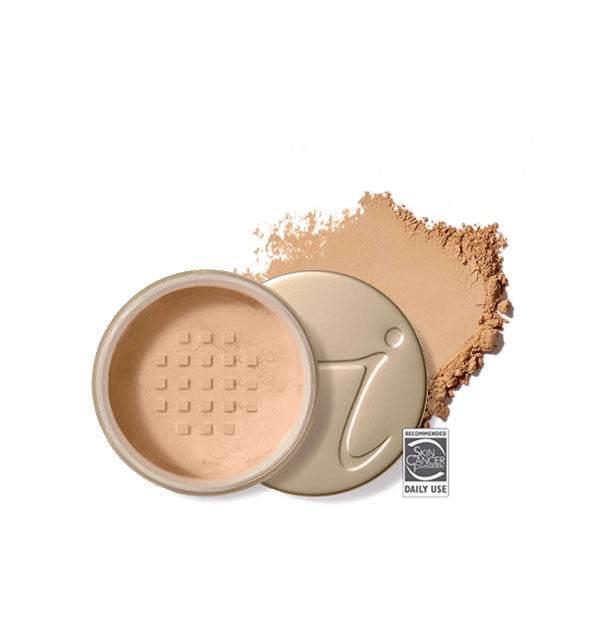 Opened round Jane Iredale loose powder compact with stamped gold lid and product application behind it in shade Suntan
