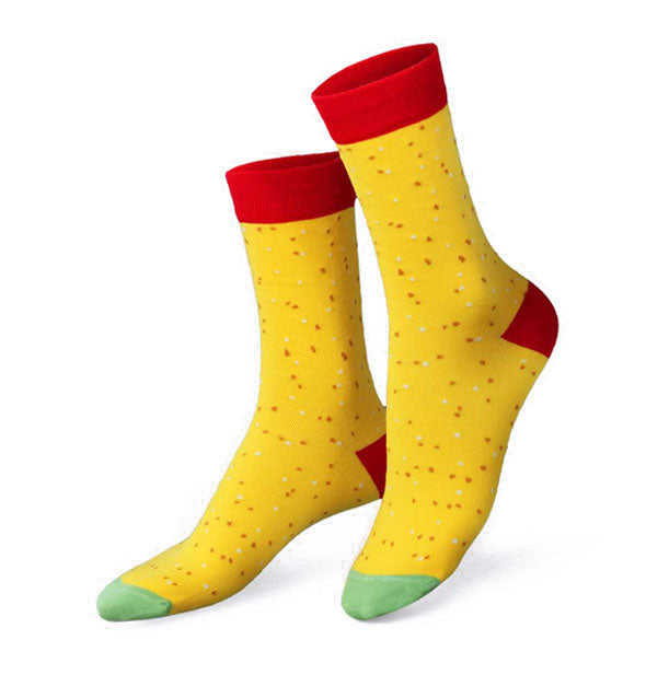 Pair of yellow crew socks with small red flecks, red top band and heel, and green toe